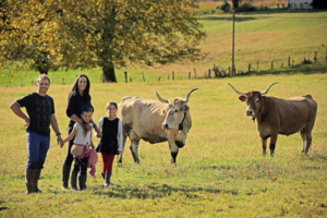 a smiling family and cows in a field