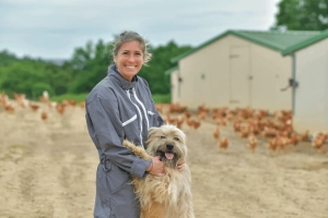 Woman and dog on poultry farm