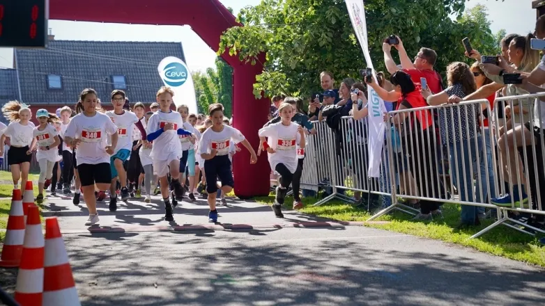 children running in front of a Ceva flag